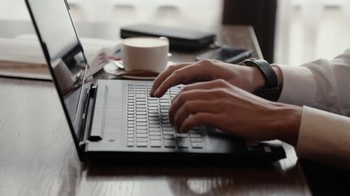 Man's Hands Are Typing On a Laptop