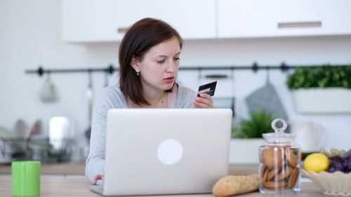 Woman Using Laptop with Credit Card at Home