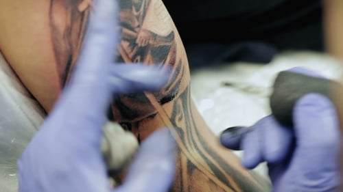 Professional Tattoo Master Draws On Man's Shoulder.