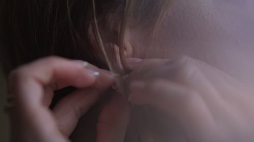 Woman Puts On Silver Earring Close Up