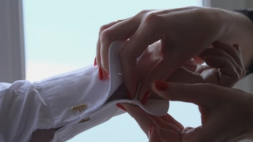 Woman helping man with cuff links