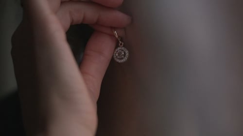 Woman Putting on an Elegant Gold Earring