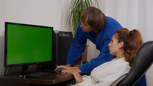 Businessman and Businesswoman in Home Clothes at Home with Green Screen Chroma Key PC on the Table