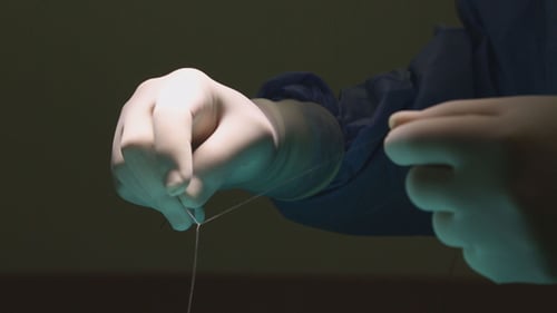 Surgeon Tying Knot with Suture