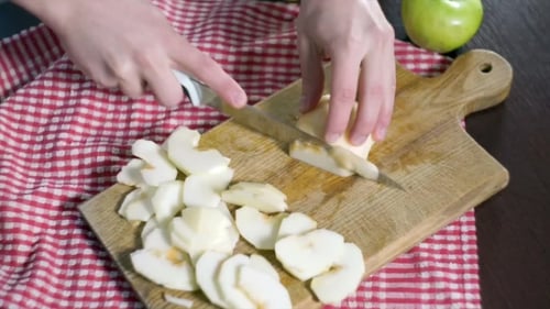Peeled Green Apple being Sliced on Cutting Board