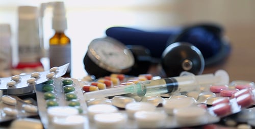 Medical Equipment, Pills, and Medications on Table
