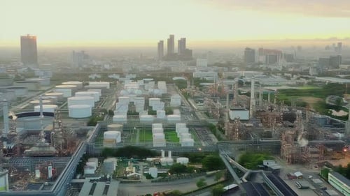 4k aerial view drone of refinery oil petroleum production factory with river reflecting surface