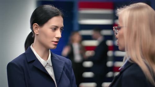 Zwei stilvolle Geschäftsfrauen genießen freundliche Kommunikation an einem modernen Büroarbeitsplatz und besprechen den Job