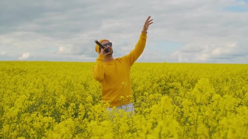 Young Man Sings in a Yellow Flower Field