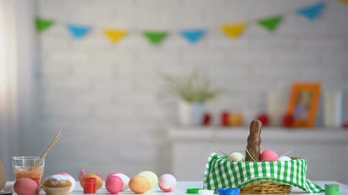 Kleines Mädchen taucht langsam unter dem Tisch auf und bewundert bunte Ostereier