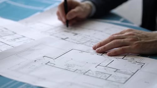 Architect Reviewing Blueprints with Pen Close Up