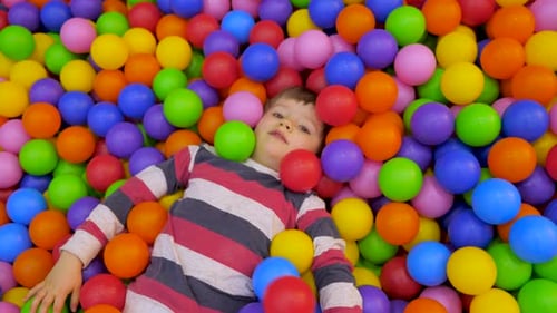 Petit garçon jouant dans la piscine avec des balles en plastique dans la crèche. Le gosse nage