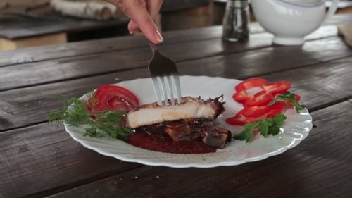 Cutting Grilled Meat with Sauce on Plate