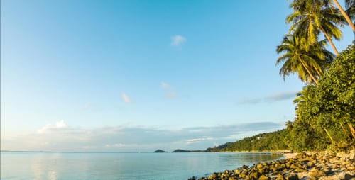 Wilder Strand mit Felsen bei Sonnenuntergang