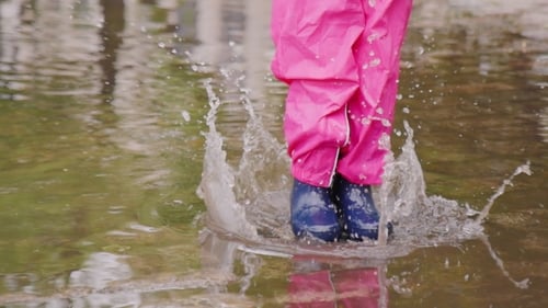 Fun Spring - Girl Jumping In a Puddle