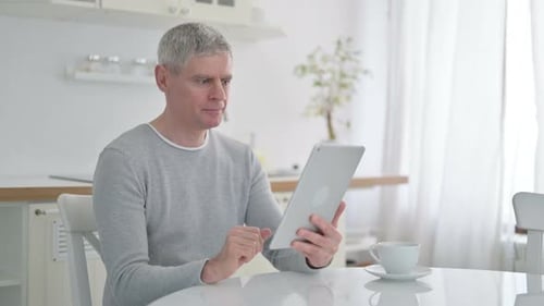 Man Uses Tablet for Video Call Indoors