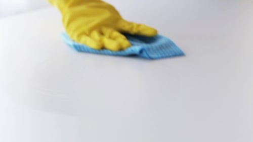 Gloved Hand Wiping a Surface Clean with Cloth