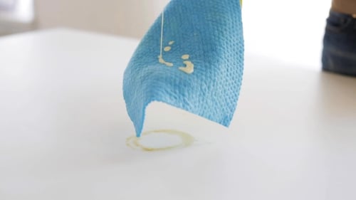 Cleaning a Table with a Rag and Gloves