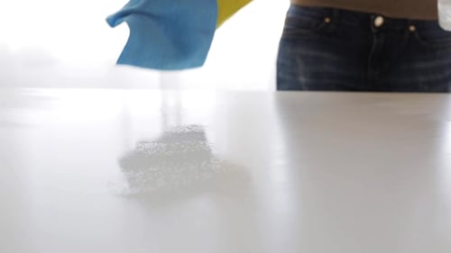 Person Cleaning White Surface Wearing Yellow Gloves