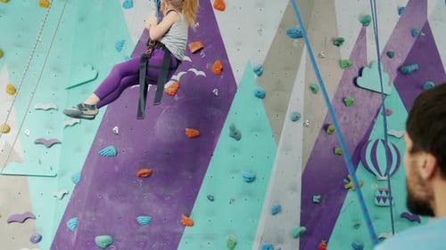 Girl Rock Climbing in an Indoor Gym
