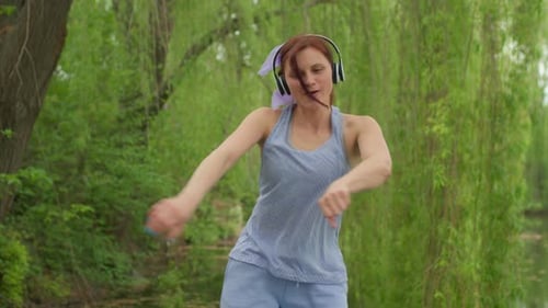 Auburn Haired Woman Joyfully Dancing in Nature