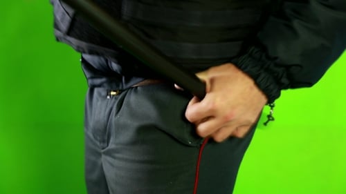 Officer Putting Away Baton on Green Screen