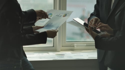 Team Discusses Charts and Tablet in Office