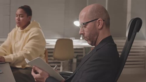 Geschäftsmann macht sich nachts im Büro Notizen