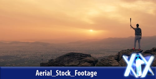 Figure Stands Triumphant on Mountain at Sunset