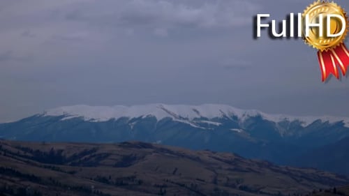Wolken bewegen sich über eine verschneite Berglandschaft