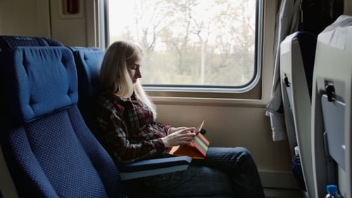 Junge Frau benutzt Tablet auf Reisen mit dem Zug