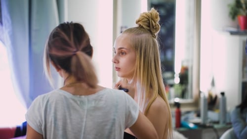 Makeup Artist Applying Makeup to Young Woman