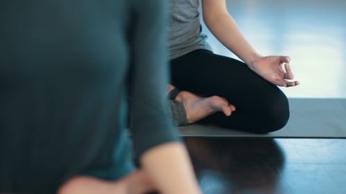 Two Women Practicing Yoga Meditation Indoors