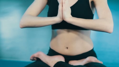 Woman Meditating Indoors in Lotus Prayer Pose