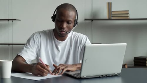 Focused Young Adult Working at Desk With Laptop
