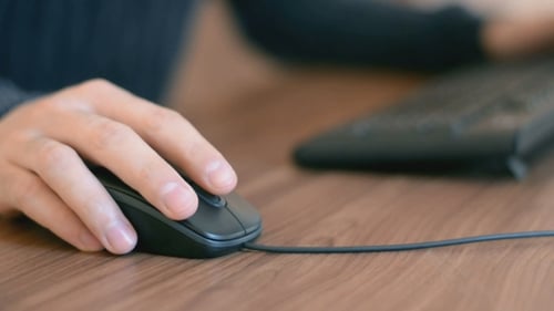 Hand Operating Computer Mouse at Desk Close Up