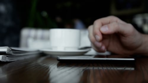 Man Using Smartphone In Cafe
