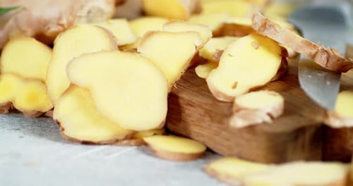 Fresh Ginger Slices on a Wooden Cutting Board