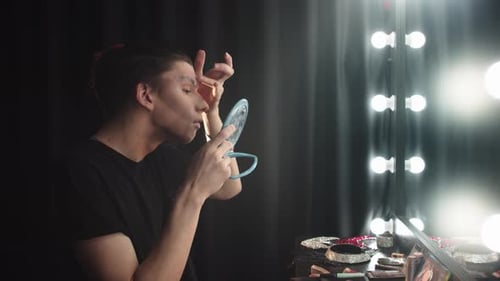 Young Adult Applying Makeup at Vanity Mirror