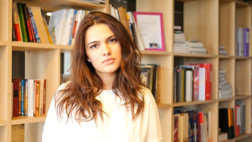 Young Adult Woman in Front of Bookshelf