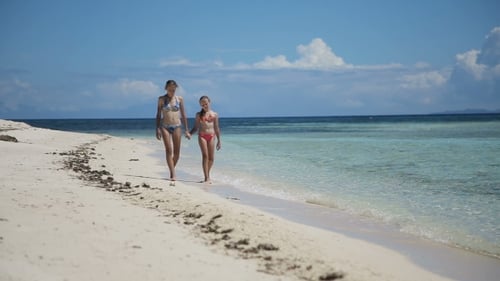 Two Girls Walking On a Tropical Beach