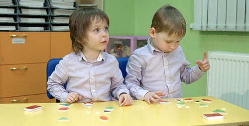 Two Boys Study the Geometric Shapes