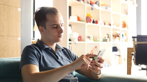 Man Using Smartphone while Sitting on Sofa