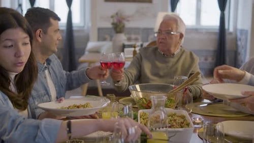 Family Gathering at Dinner Table toasting with wine