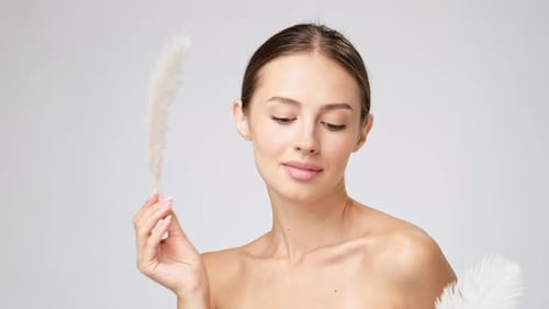 Beautiful Woman Posing with Feathers in Studio