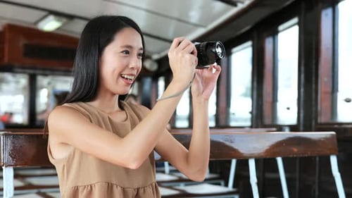 Woman taking photo with digital camera on ferry