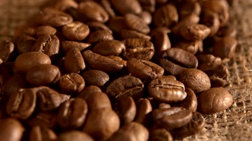 Handful of Coffee Beans on Burlap Sacking, Background, Close Up, Rotation