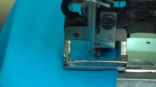Fabrikschneiderin bei der Arbeit und Industrienähmaschine