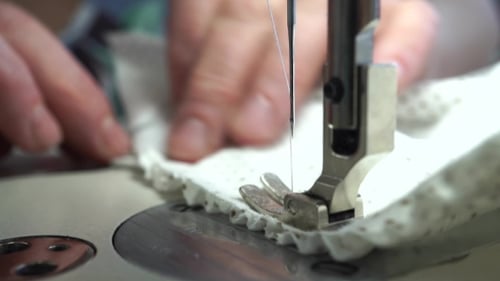 Factory Seamstress At Work And Industrial Sewing Machine