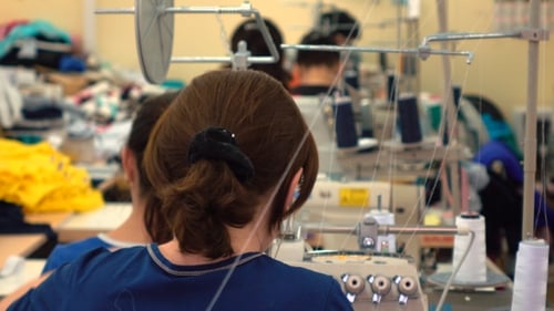 Fabrikschneiderin bei der Arbeit und Industrienähmaschine